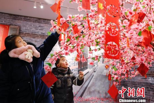 孩子們在許愿樹下寫下新年祝福。 殷立勤 攝