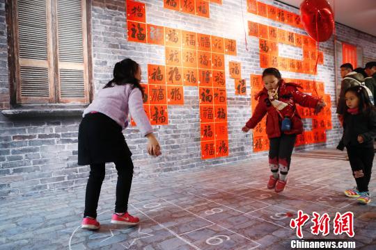 孩子在“福”字墻前玩起了上海的弄堂游戲造房子。 殷立勤 攝