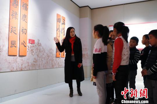 上海市文聯工作人員為孩子們講解春聯。 殷立勤 攝
