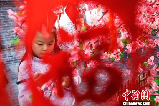 孩子在許愿樹下寫下新年祝福。 殷立勤 攝