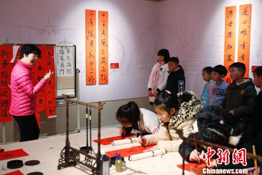 孩子在老師的指點下書寫春聯。 殷立勤 攝