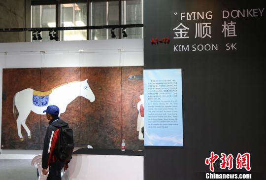 韓國參展企業(yè)展位前，一位游客正在欣賞作品。　姜濤 攝